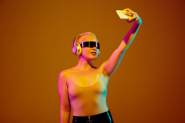 Image showing Portrait of young caucasian woman in fashionable eyewear on brown background with copyspace, unusual and freaky appearance