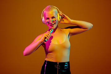 Image showing Portrait of young caucasian woman in fashionable eyewear on brown background with copyspace, unusual and freaky appearance