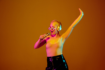 Image showing Portrait of young caucasian woman in fashionable eyewear on brown background with copyspace, unusual and freaky appearance