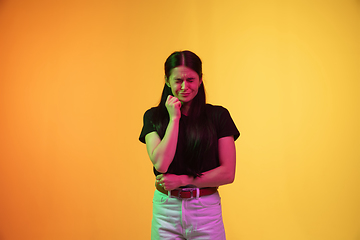 Image showing Caucasian young woman\'s portrait on yellow background in neon light