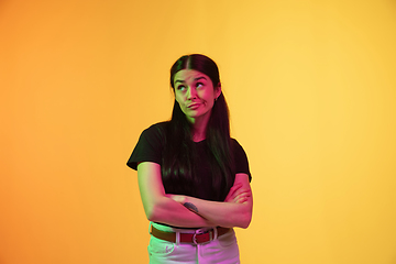 Image showing Caucasian young woman\'s portrait on yellow background in neon light