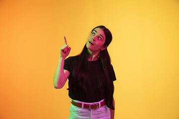 Image showing Caucasian young woman\'s portrait on yellow background in neon light