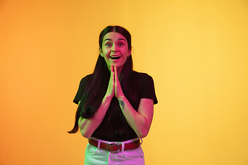 Image showing Caucasian young woman\'s portrait on yellow background in neon light