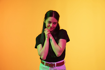 Image showing Caucasian young woman\'s portrait on yellow background in neon light