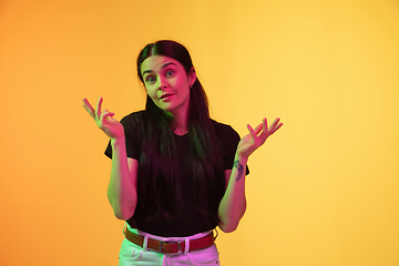 Image showing Caucasian young woman\'s portrait on yellow background in neon light