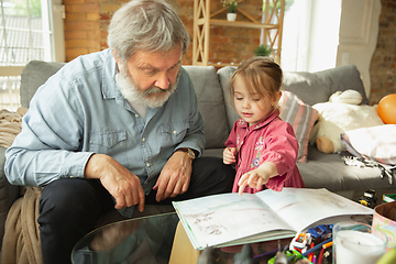 Image showing Grandfather and child playing together at home. Happiness, family, relathionship, education concept.