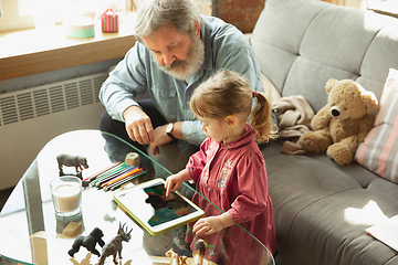 Image showing Grandfather and child playing together at home. Happiness, family, relathionship, education concept.