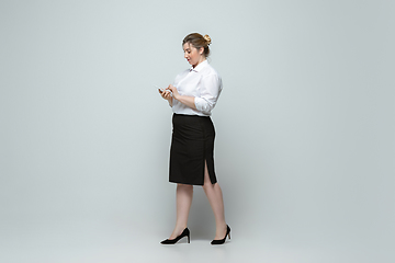 Image showing Young caucasian woman in office attire on gray background. Bodypositive female character. plus size businesswoman