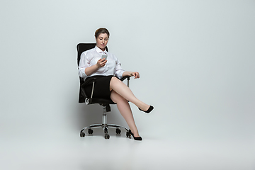 Image showing Young caucasian woman in office attire on gray background. Bodypositive female character. plus size businesswoman