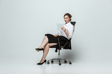 Image showing Young caucasian woman in office attire on gray background. Bodypositive female character. plus size businesswoman