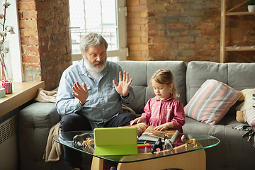 Image showing Grandfather and child playing together at home. Happiness, family, relathionship, education concept.