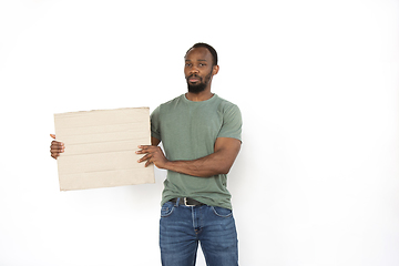 Image showing Young man protesting with blank board, sign isolated on white studio background