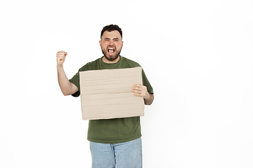 Image showing Young man protesting with blank board, sign isolated on white studio background