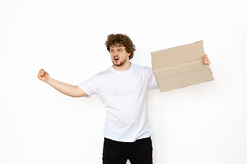 Image showing Young man protesting with blank board, sign isolated on white studio background