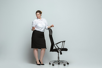 Image showing Young caucasian woman in office attire on gray background. Bodypositive female character. plus size businesswoman