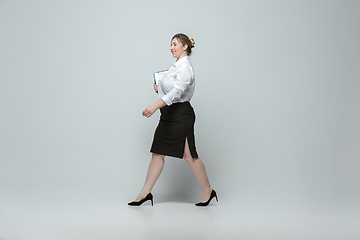 Image showing Young caucasian woman in office attire on gray background. Bodypositive female character. plus size businesswoman