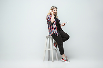 Image showing Young caucasian woman in casual wear on gray background. Bodypositive female character, plus size businesswoman