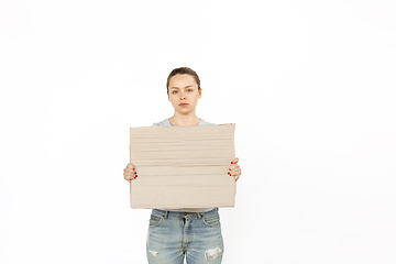 Image showing Young woman protesting with blank board, sign isolated on white studio background