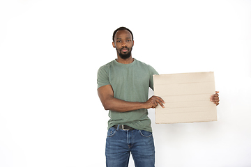 Image showing Young man protesting with blank board, sign isolated on white studio background