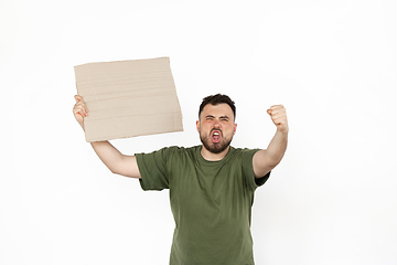 Image showing Young man protesting with blank board, sign isolated on white studio background