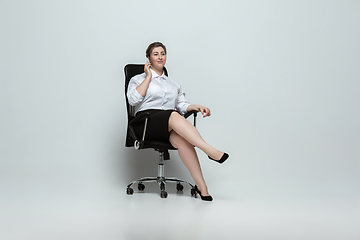 Image showing Young caucasian woman in office attire on gray background. Bodypositive female character. plus size businesswoman