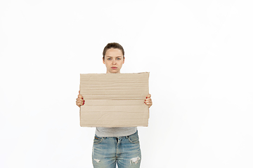 Image showing Young woman protesting with blank board, sign isolated on white studio background