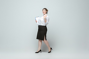 Image showing Young caucasian woman in office attire on gray background. Bodypositive female character. plus size businesswoman