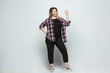 Image showing Young caucasian woman in casual wear on gray background. Bodypositive female character, plus size businesswoman