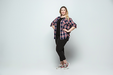 Image showing Young caucasian woman in casual wear on gray background. Bodypositive female character, plus size businesswoman