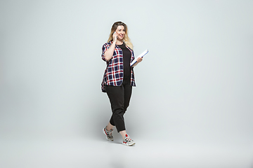 Image showing Young caucasian woman in casual wear on gray background. Bodypositive female character, plus size businesswoman