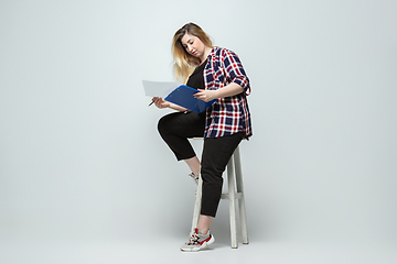Image showing Young caucasian woman in casual wear on gray background. Bodypositive female character, plus size businesswoman