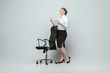 Image showing Young caucasian woman in office attire on gray background. Bodypositive female character. plus size businesswoman