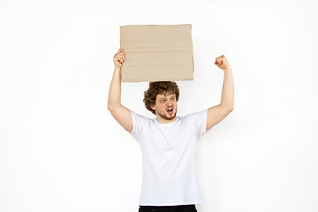 Image showing Young man protesting with blank board, sign isolated on white studio background