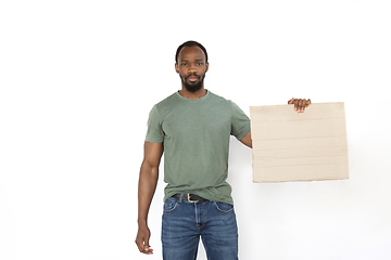 Image showing Young man protesting with blank board, sign isolated on white studio background