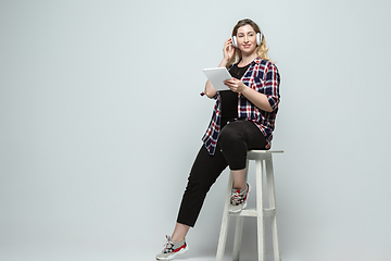 Image showing Young caucasian woman in casual wear on gray background. Bodypositive female character, plus size businesswoman