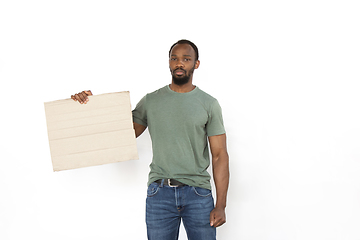 Image showing Young man protesting with blank board, sign isolated on white studio background