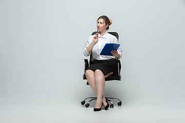 Image showing Young caucasian woman in office attire on gray background. Bodypositive female character. plus size businesswoman