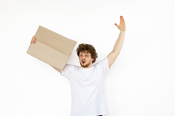 Image showing Young man protesting with blank board, sign isolated on white studio background