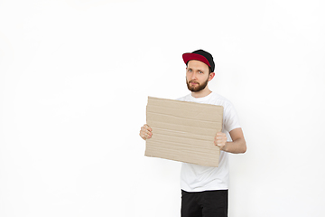 Image showing Young man protesting with blank board, sign isolated on white studio background