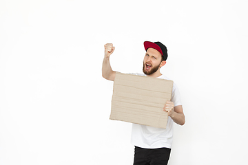 Image showing Young man protesting with blank board, sign isolated on white studio background