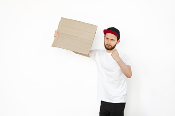 Image showing Young man protesting with blank board, sign isolated on white studio background