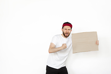 Image showing Young man protesting with blank board, sign isolated on white studio background