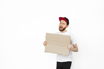 Image showing Young man protesting with blank board, sign isolated on white studio background