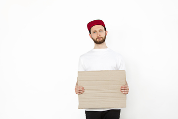 Image showing Young man protesting with blank board, sign isolated on white studio background