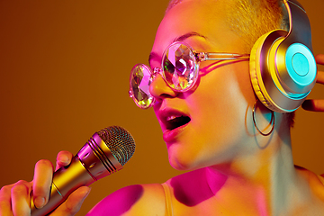 Image showing Portrait of young caucasian woman in fashionable eyewear on brown background with copyspace, unusual and freaky appearance