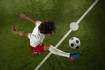 Image showing Top view of caucasian football or soccer player on green background of grass in action and motion