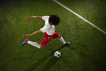 Image showing Top view of caucasian football or soccer player on green background of grass in action and motion