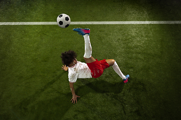 Image showing Top view of caucasian football or soccer player on green background of grass in action and motion