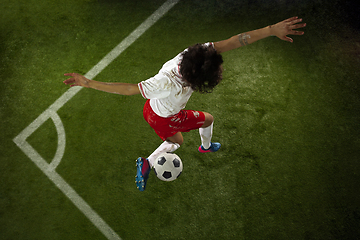 Image showing Top view of caucasian football or soccer player on green background of grass in action and motion