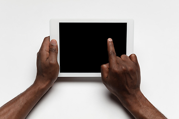 Image showing Close up of human hand using tablet with blank black screen, education and business concept